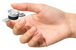 A hand holding a thermal switch