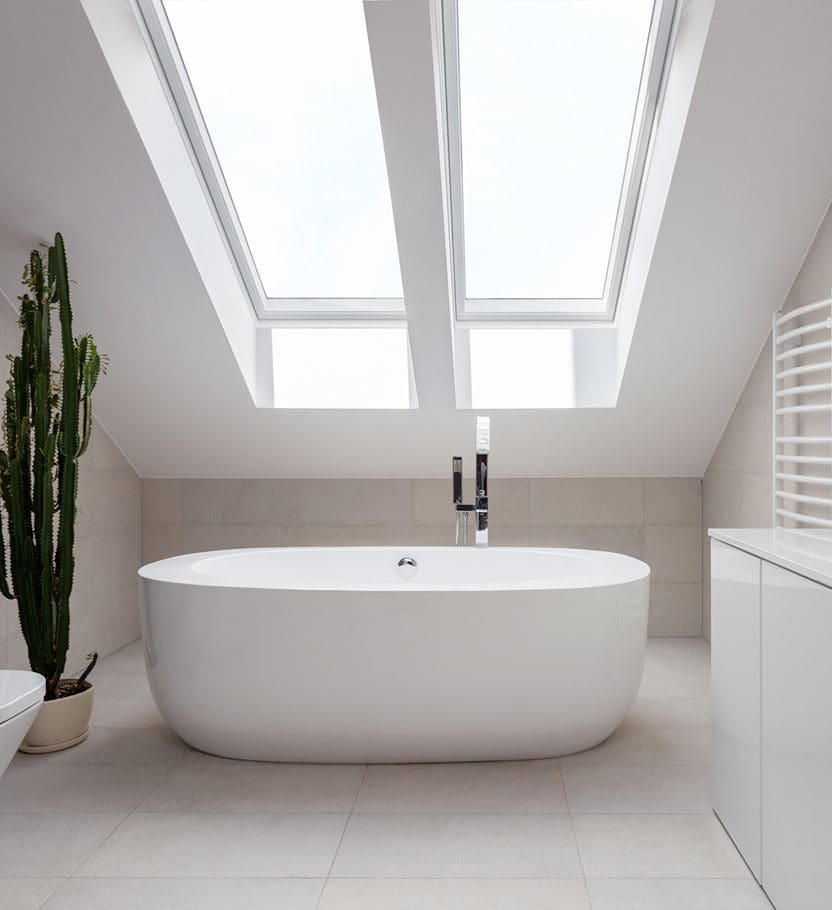 A bathtub underneath a skylight