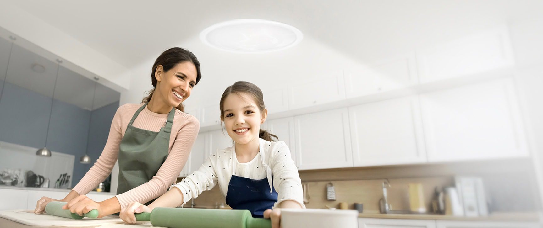 A mother and daughter in the kitchen underneath a solatube skylight