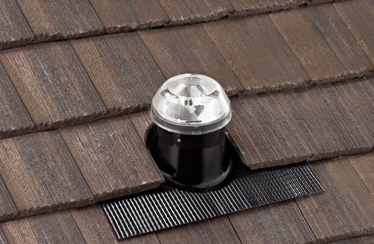 A solatube dome on a flat tile roof