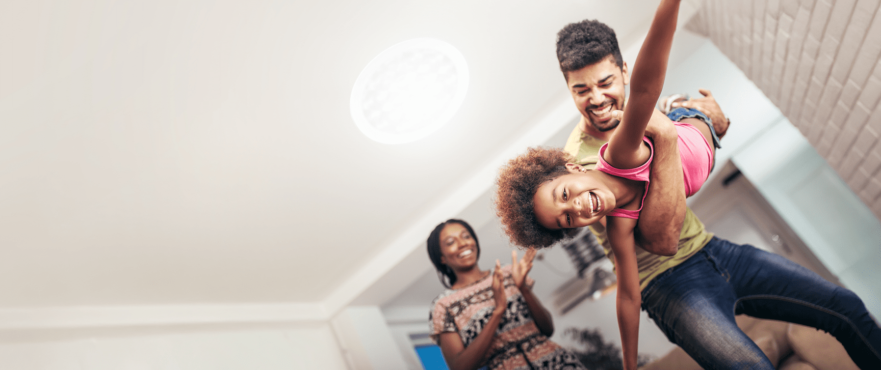 Man playing with daughter under a Solatube skylight