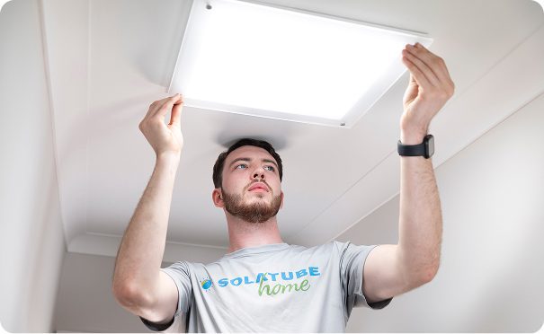 A man in a solatube tshirt installing a solatube